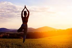 Woman doing yoga against a natural landscape for wellness